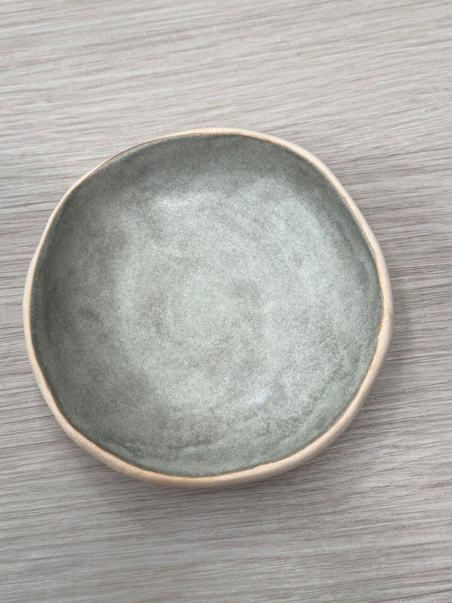 Gray ceramic plate on a wooden surface